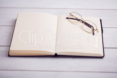 Empty notepad with reading glasses