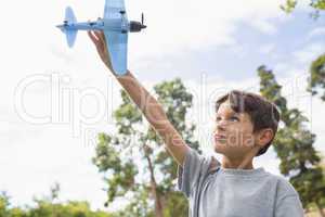 Boy playing with a toy plane at park