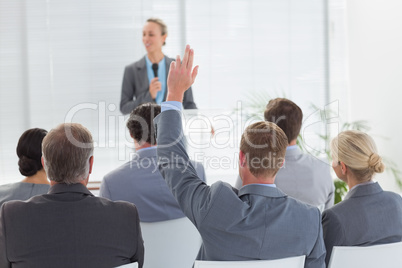 Pretty businesswoman talking in microphone during conference