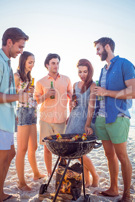 Happy friends doing barbecue and drinking beer