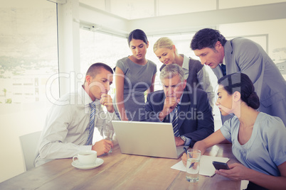 Concentrated business team working on laptop