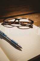 Empty notepad with reading glasses