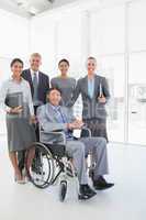 Disabled businessman with his colleagues smiling at camera
