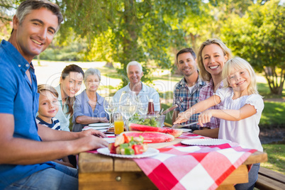 Happy family having picnic and holding american flag