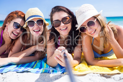 Happy friends wearing sun glasses and taking selfie