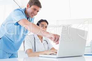 Doctors working with laptop computer