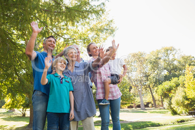 Happy family waving hands in the park