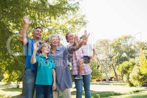 Happy family waving hands in the park