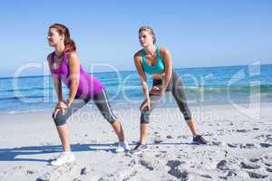 Friends stretching together beside the water