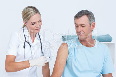 Doctor doing an injection to her patient