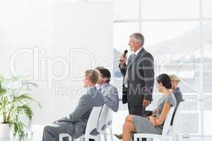 Businessman talking in microphone during conference