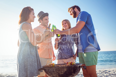 Happy friends doing barbecue and drinking beer