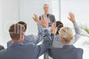 Business team raising hands during conference