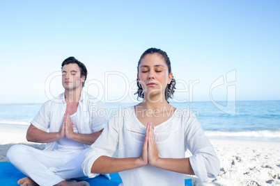 Happy couple doing yoga beside the water Happy couple doing yoga beside the water