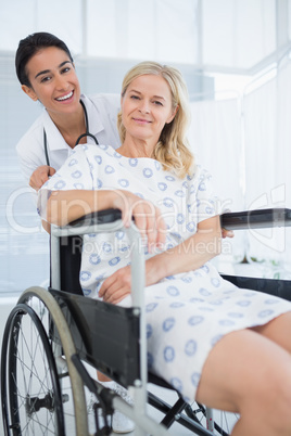 Doctor and patient in wheelchair smiling at camera