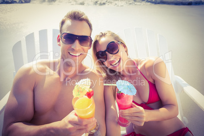 Happy couple enjoying cocktails on the beach