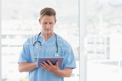 Doctor writing on clipboard beside windows Doctor writing on clipboard beside windows