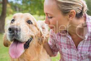 Happy blonde with her dog in the park