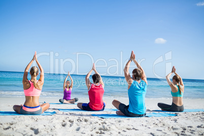 Friends doing yoga together with their teacher