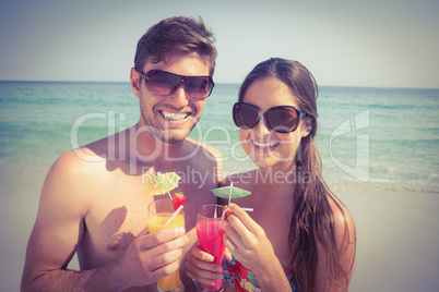 Happy couple having cocktails on beach