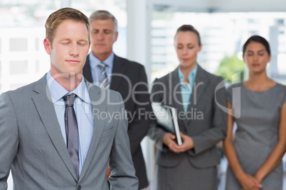 Business team meditating eyes closed