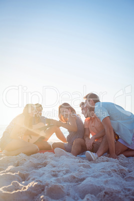 Happy hipsters relaxing and playing guitar