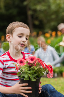 Young boy sitting with flower pot
