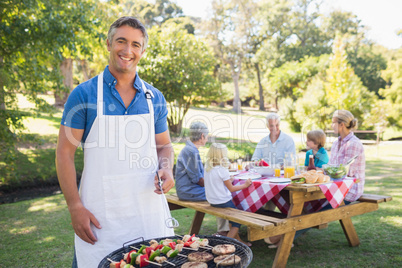 Happy man doing barbecue for his family