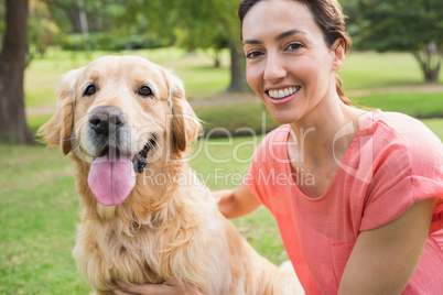 Pretty brunette looking at camera with her dog