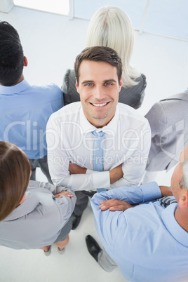 Businessman looking at camera with his colleague around him