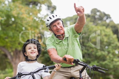 Happy grandfather with his granddaughter on their bike