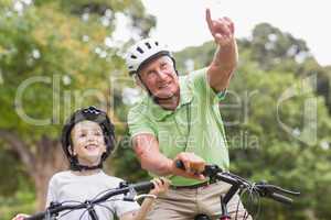 Happy grandfather with his granddaughter on their bike