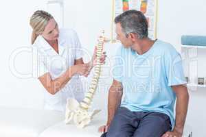 Doctor showing her patient a spine model