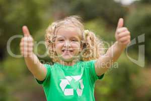 Happy little girl in green with thumbs up