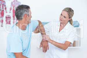 Doctor stretching a man arm