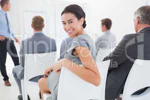 Smiling businesswoman looking at camera during conference