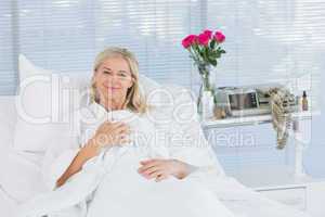 Smiling patient looking at camera on her bed
