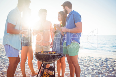 Happy friends doing barbecue and drinking beer