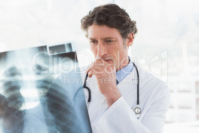 Serious doctor looking at X-ray