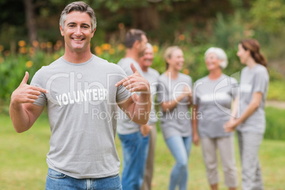 Happy volunteer showing his t-shirt to camera