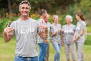 Happy volunteer showing his t-shirt to camera