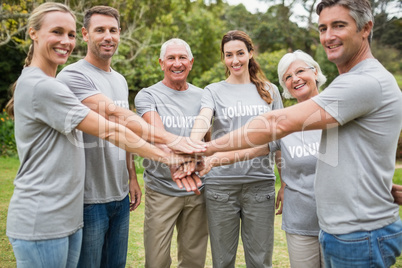 Happy volunteer family putting their hands together