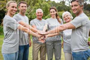 Happy volunteer family putting their hands together