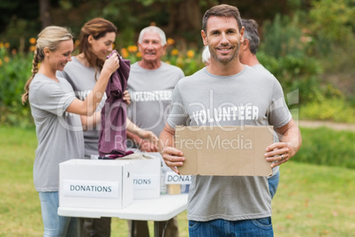 Happy volunteer family holding donation boxes