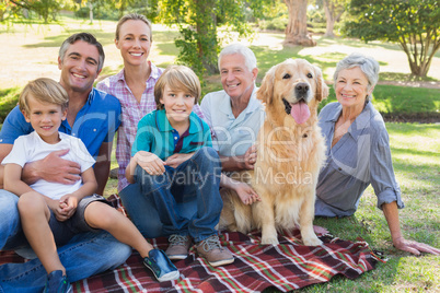 Happy family smiling at the camera with their dog