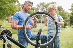 Father and his son fixing a bike