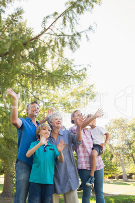 Happy family waving hands in the park