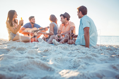 Happy hipsters relaxing and playing guitar