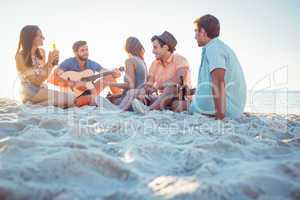 Happy hipsters relaxing and playing guitar