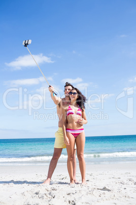 Happy couple taking selfie with selfie stick